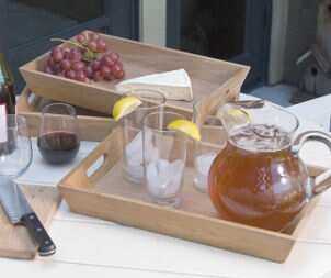 Wooden serving trays hold iced tea, grapes and cheese