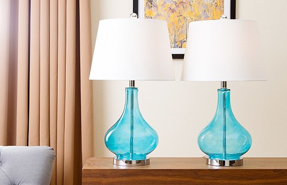 A set of teal table lamps sitting on a table.