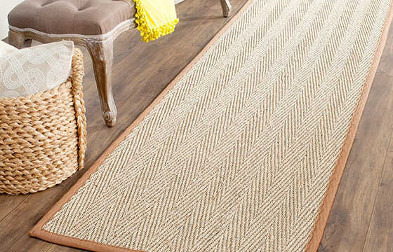 A natural jute runner area rug with an orange edge.