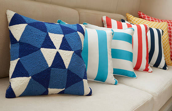 A close up of colorful throw pillows on a couch.