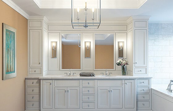 Bathroom vanity shown with three sconces and chandelier
