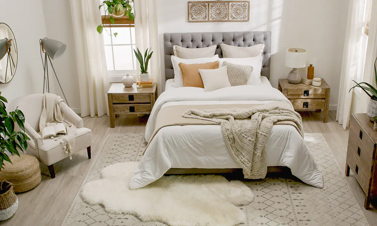 Boho bedroom with mid-range bedding: white comforter, tan coverlet, and throw pillows