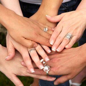 Sterling silver rings on six female hands