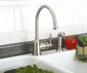 Brushed nickel kitchen faucet against a white tile backsplash