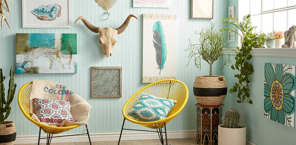 Bohemian decorated art wall with blue and green paintings, house plants, and faux animal head