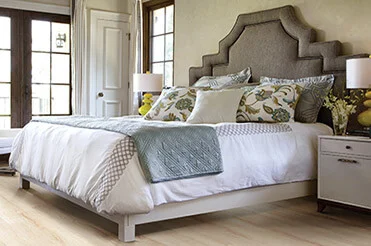 Upholstered headboard bed with wood-look laminate flooring