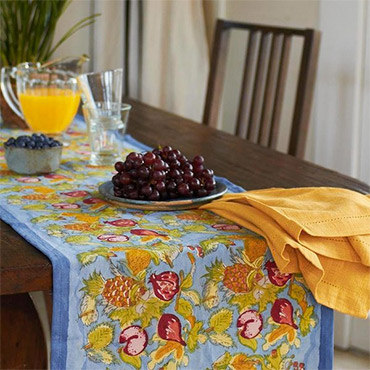 A floral print table runner on table with juice and grapes