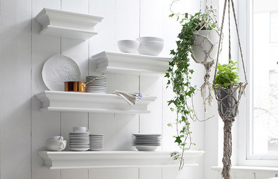 White floating shelves in a kitchen with dinnerware on them