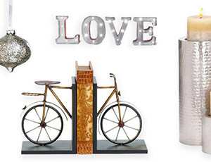 An assortment of home décor products; candle set, bookends, wall marquee, and a Christmas ornament 