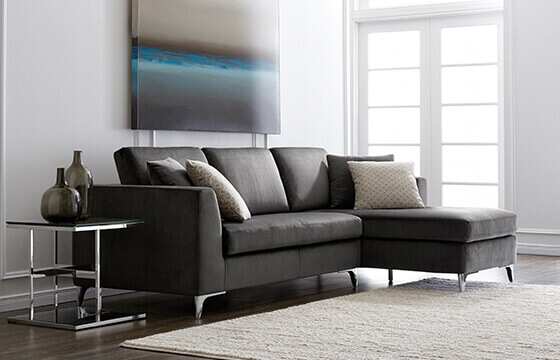 A grey modern sectional sofa with metal legs 