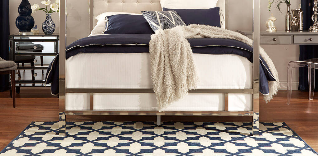 Glam bedroom with metallic and navy accents featuring a white and navy rug