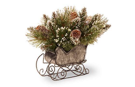 Rustic centerpiece featuring a tree needles and pinecones in a sleigh 
